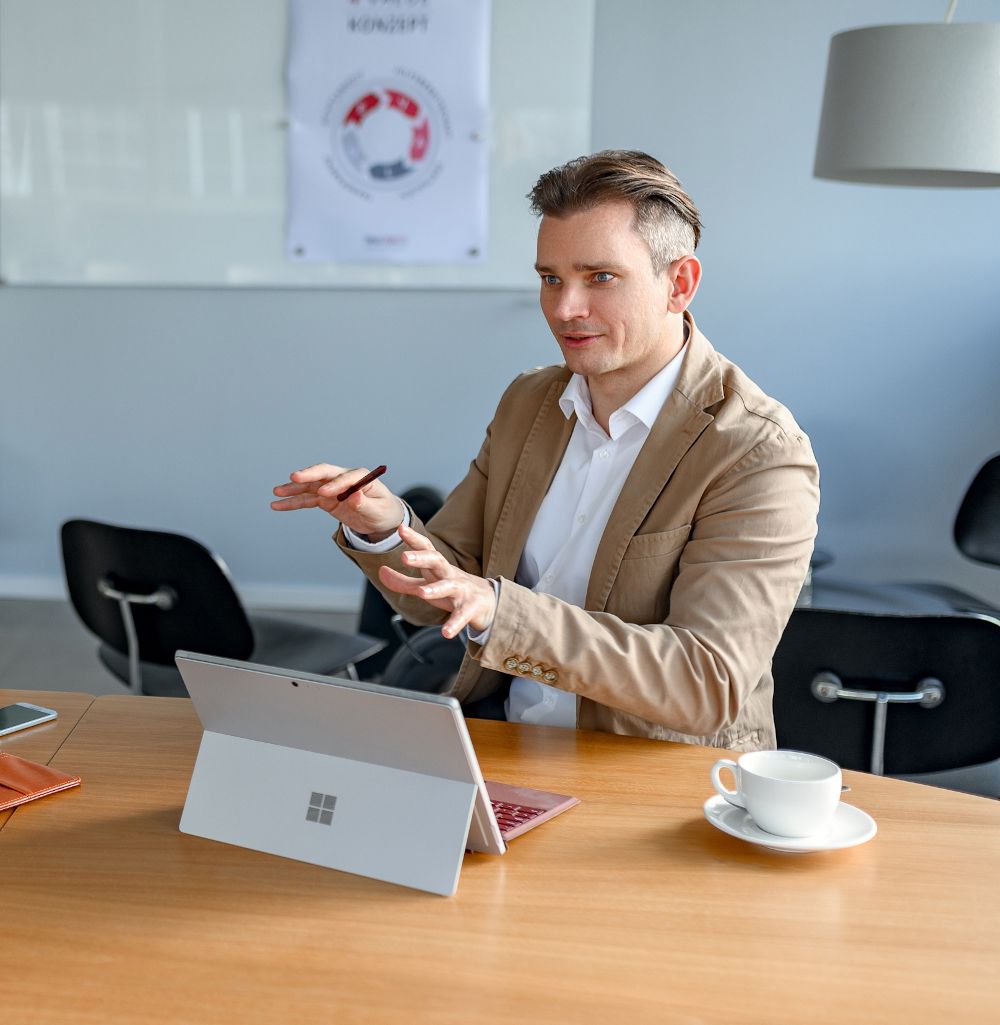 Prozessberatung und systemisches Business Coaching von Tobias Schütte sitzt mit Laptop am Tisch und berät fokussiert